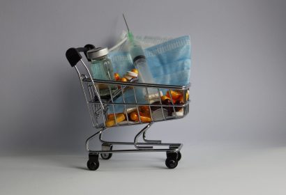 shopping cart with variety of medicine, syringe and mask